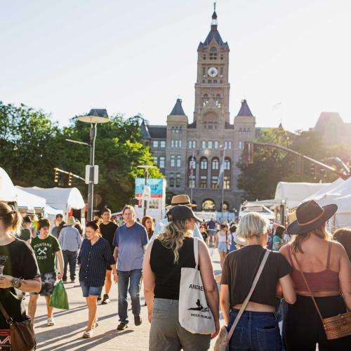 crowd of people perusing art's fest tents by city hall crowd of people perusing art's fest tents by city hall