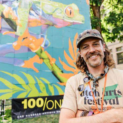 artist in front of finished 100/One mural artist in front of finished 100/One mural