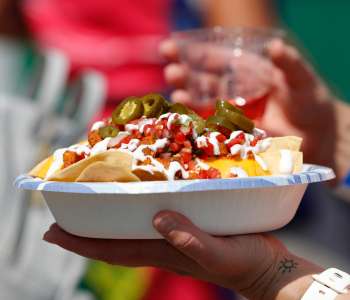 bowl of nachos with jalapenos on top