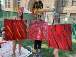 three people holding up boards painted red